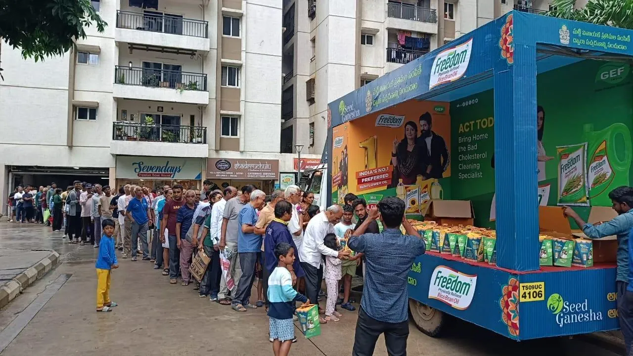 Residents queuing at a Seed Ganesha distribution van inside an apartment complex